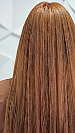 Cabello largo y liso en tono cobrizo, de espaldas