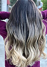 Cabello largo en degradado de raíz oscura a rubio platino